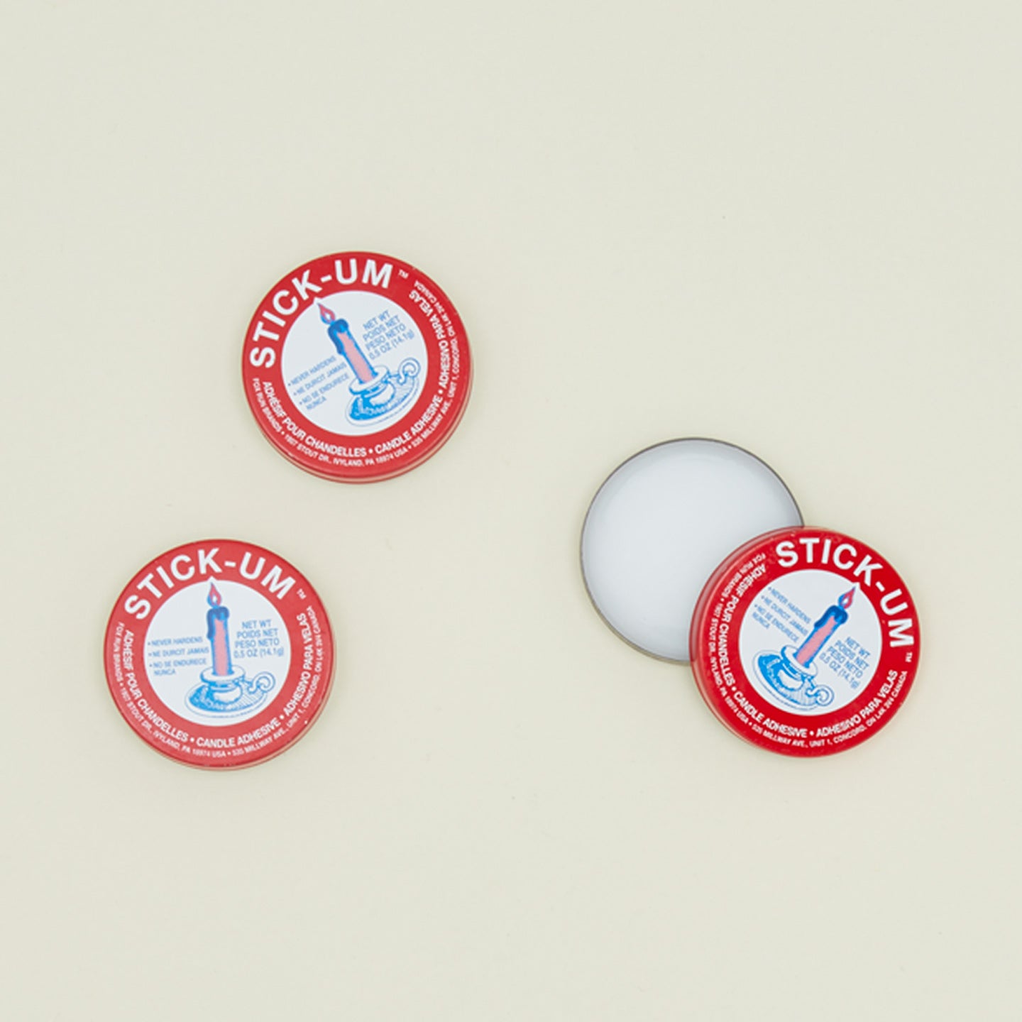 Overhead view of three containers of Stick-um candle adhesive