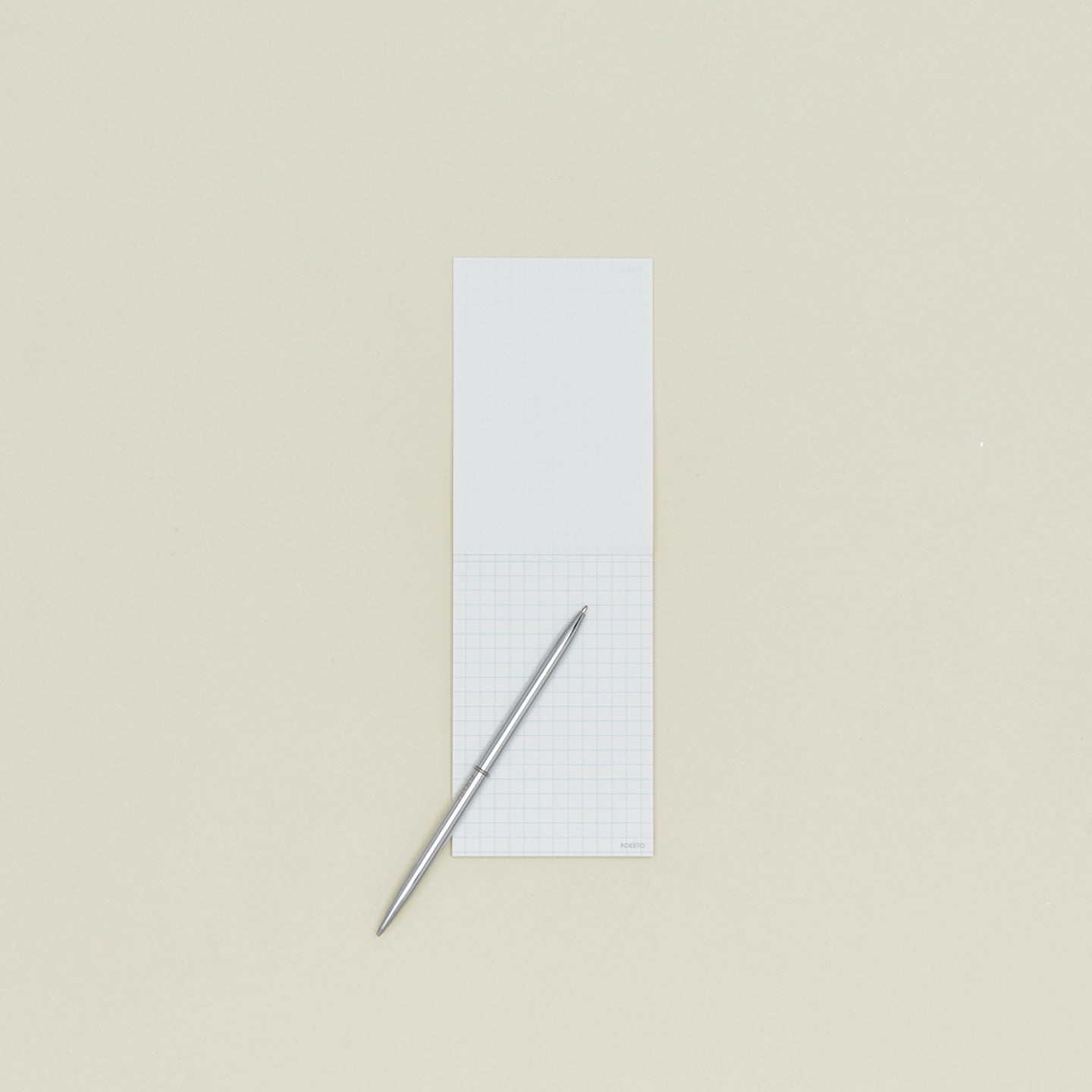 A6 grid notepad open with slim pen
