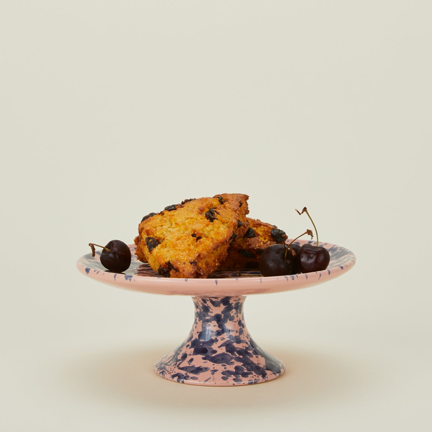 Splatter cake stand in pink and blue with scones and cherries
