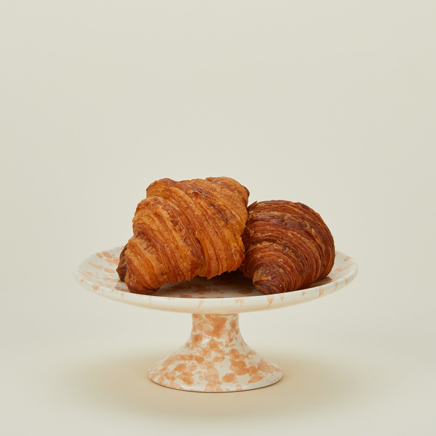 Splatter cake stand in tan and ivory with croissants
