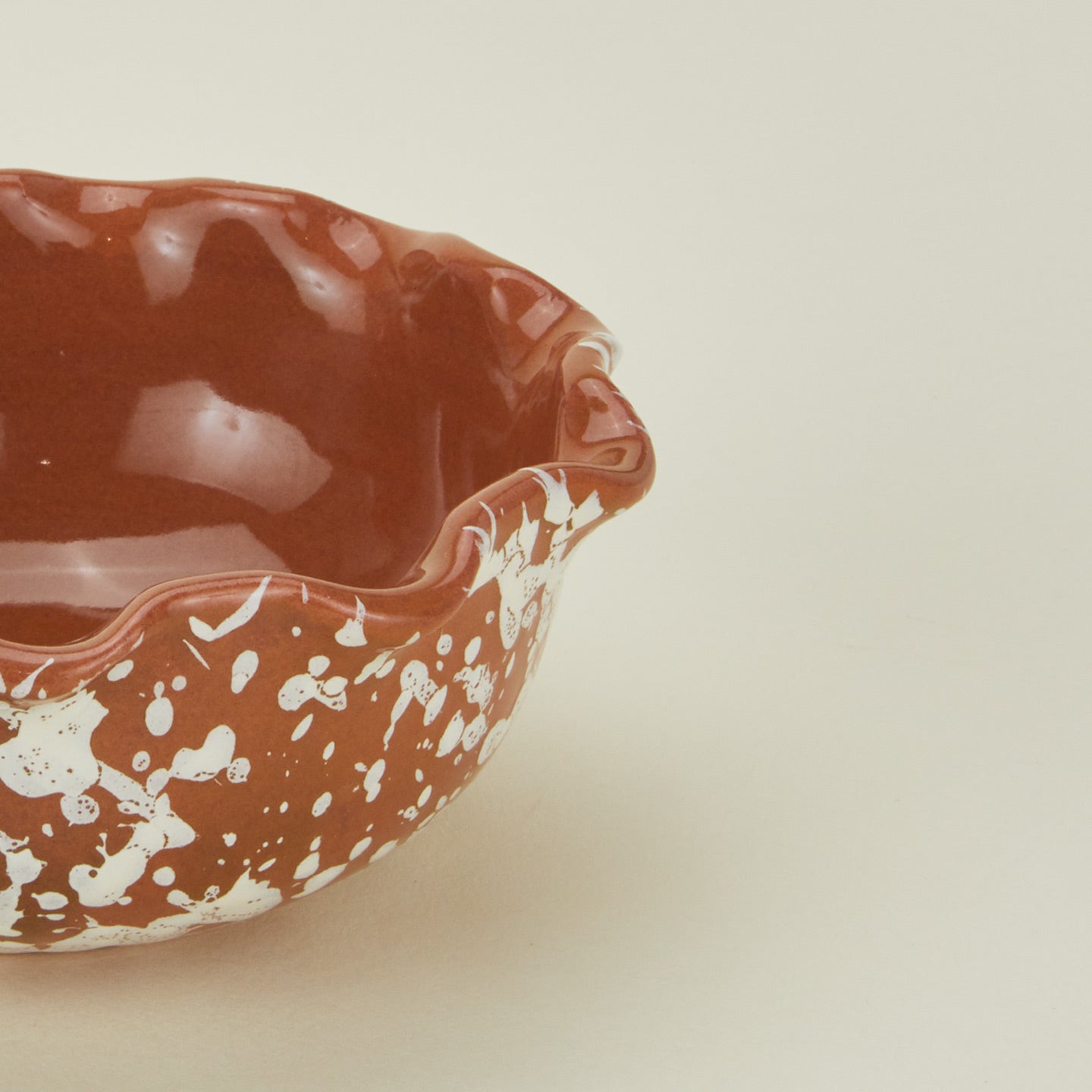 Close up view of Splatter scallop bowl in terracotta and ivory