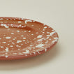 Close up view of Splatter terracotta and ivory salad plate