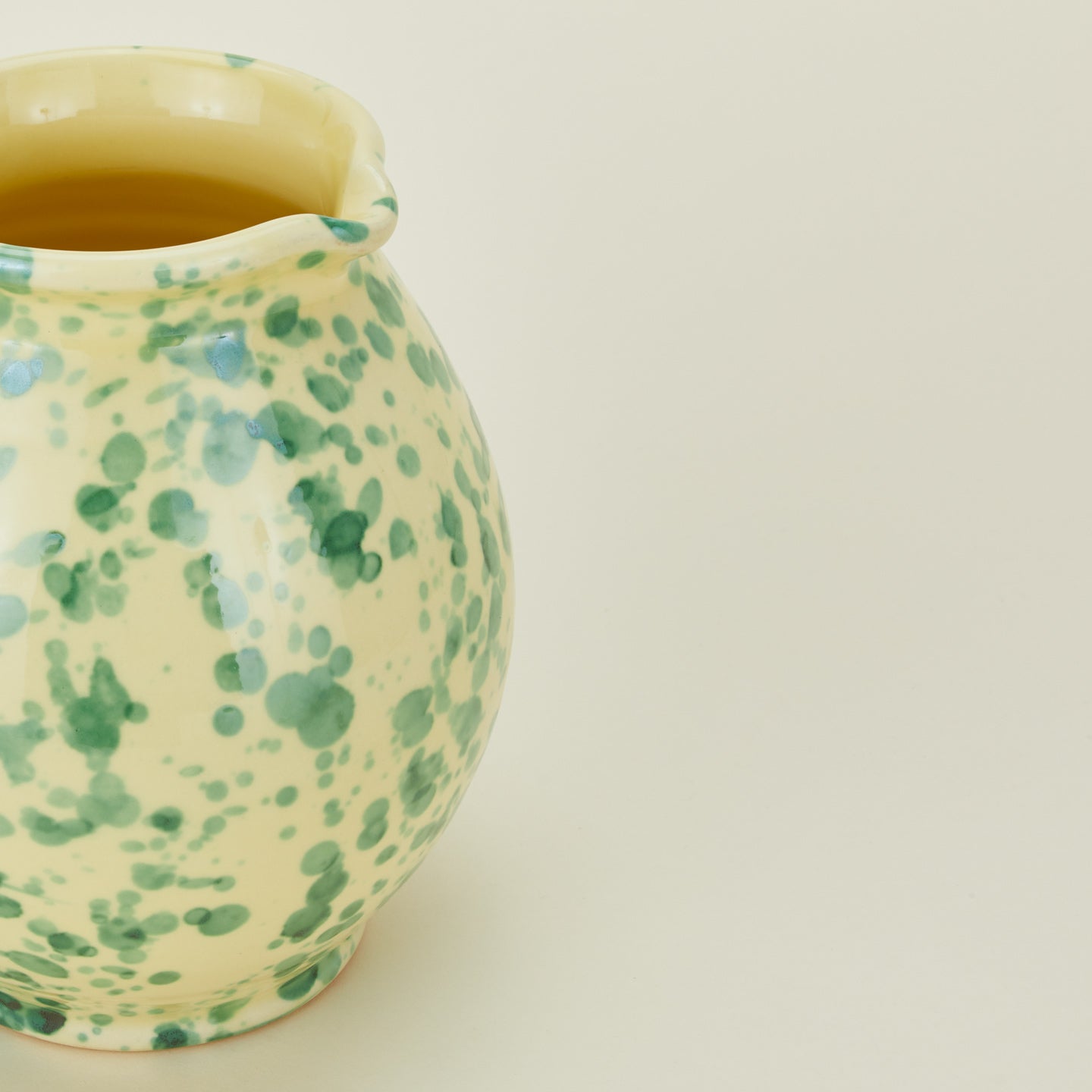 Close up view of Splatter cigno jug in yellow and green