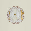 A place setting with a round quilted placemat with a floral print in Constance brown.
